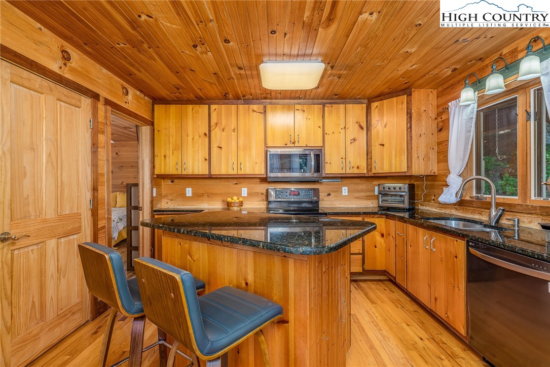 363 Misty Mountain Road Boone, NC 28607 - Photo 23 of 50 a kitchen with stainless steel appliances granite countertop sink stove top oven and cabinets