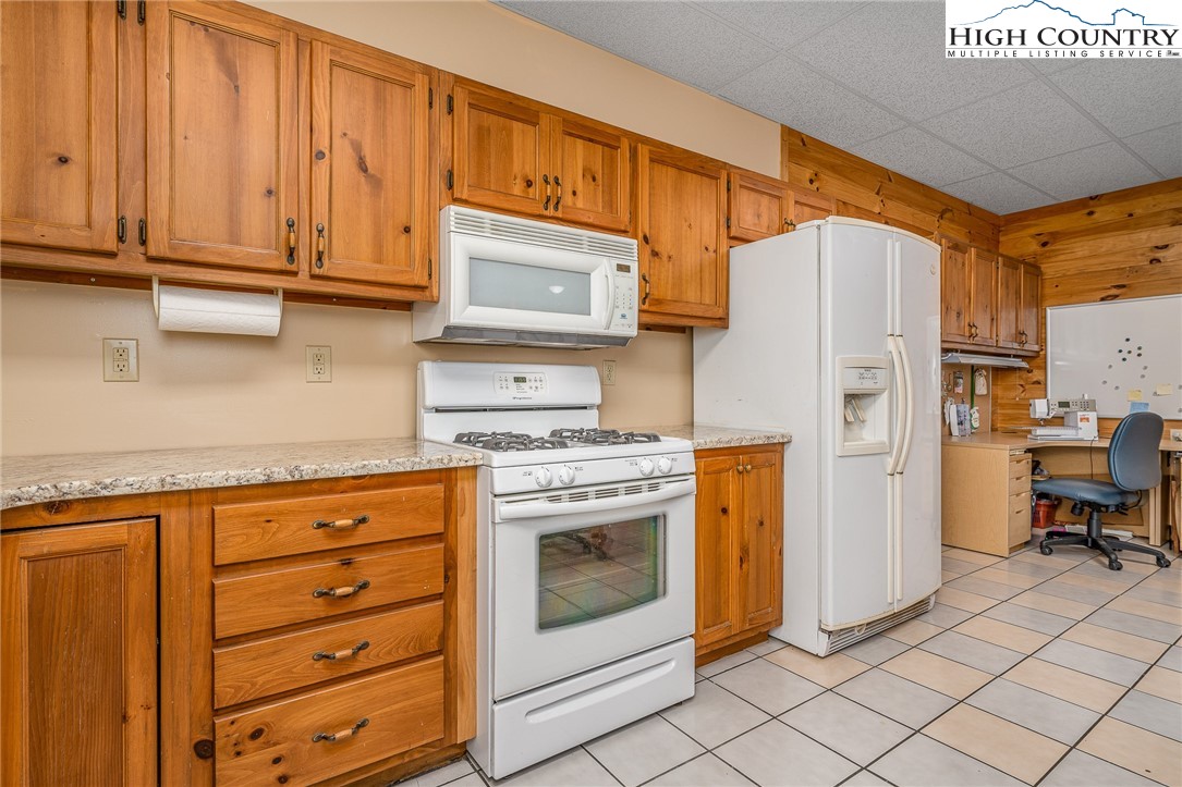 363 Misty Mountain Road Boone, NC 28607 - Photo 46 of 50 a kitchen with stainless steel appliances granite countertop a refrigerator and a stove top oven