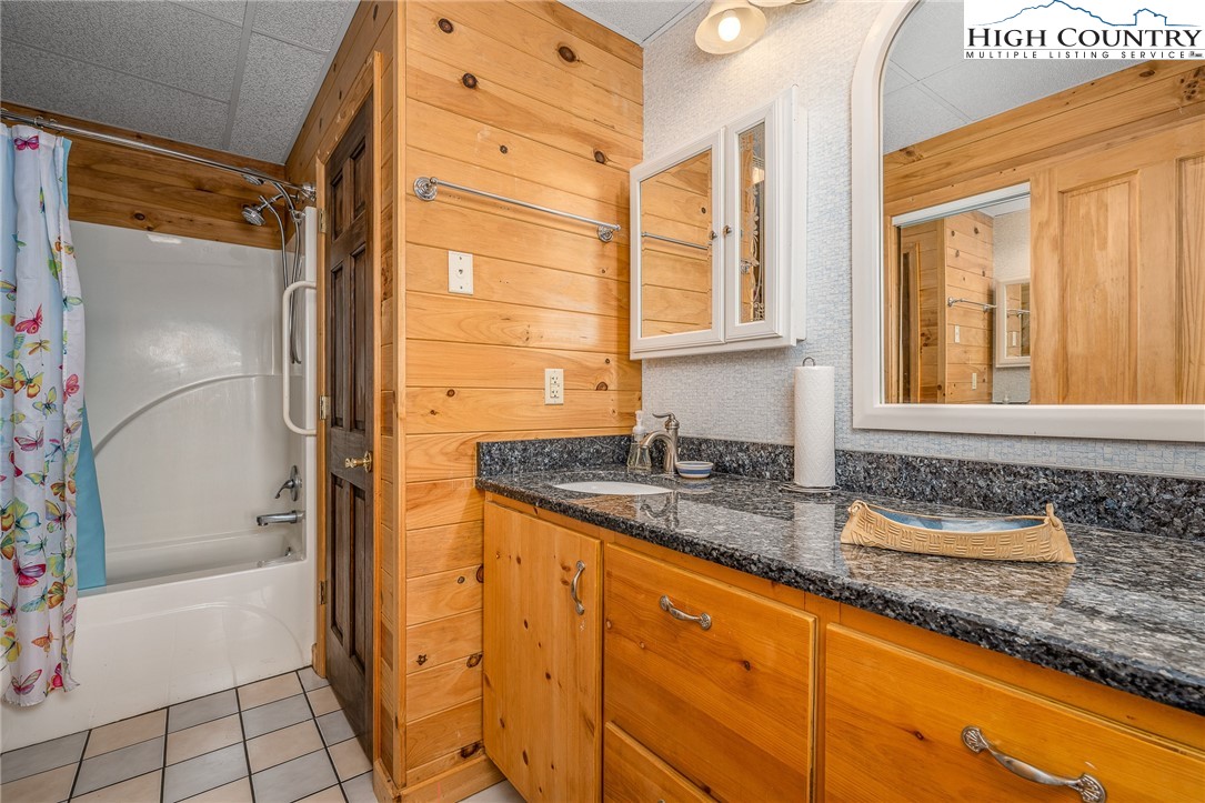 363 Misty Mountain Road Boone, NC 28607 - Photo 49 of 50 a bathroom with a granite countertop sink and a bathtub