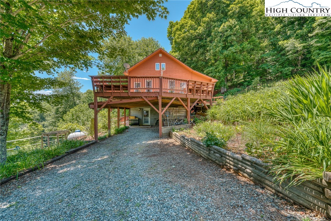 363 Misty Mountain Road Boone, NC 28607 - Photo 7 of 50 a view of a small house with a small yard plants and large trees