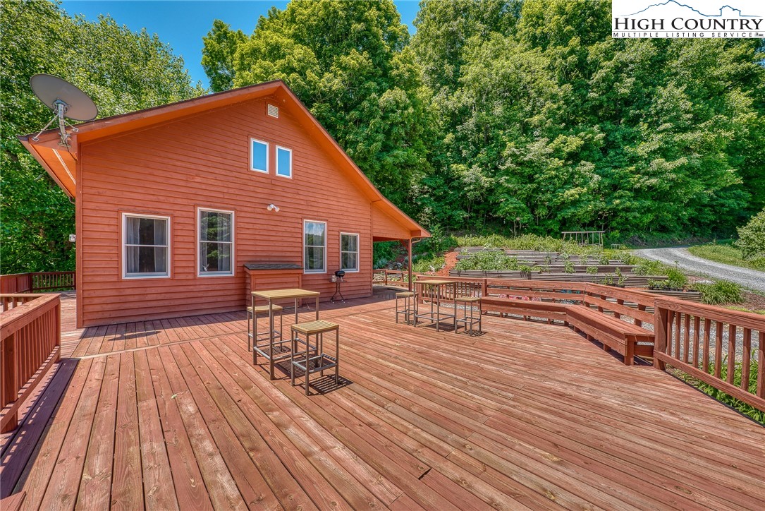 363 Misty Mountain Road Boone, NC 28607 - Photo 9 of 50 a view of house with deck outdoor seating and trees in the background