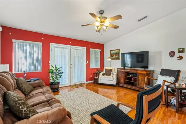 a living room with furniture a flat screen tv and a chandelier