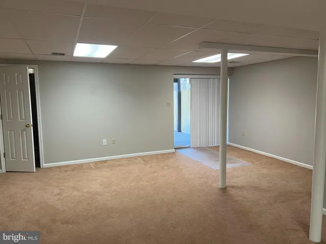 an empty room with windows and chandelier fan