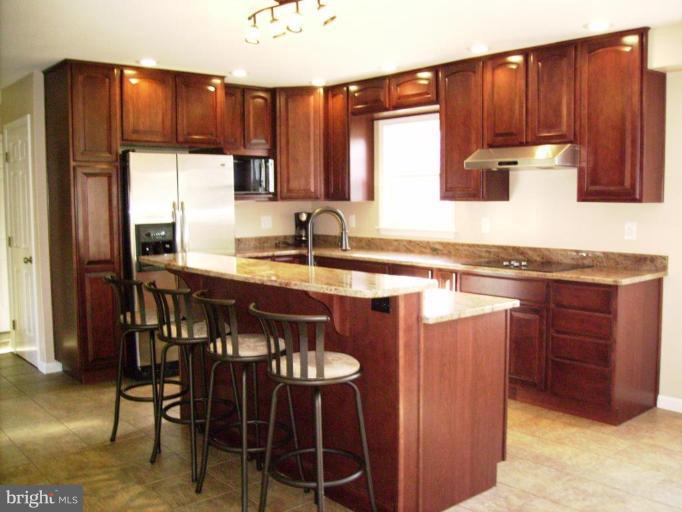 3105 Fallston Road Fallston, MD 21047 - Photo 4 of 30 a kitchen with stainless steel appliances granite countertop wooden cabinets a table and chairs