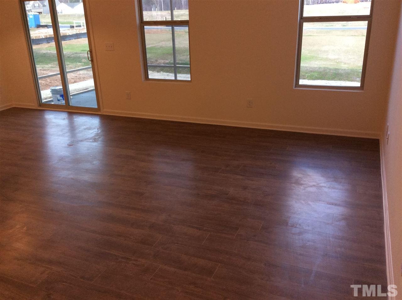 3633 Tule Spring Street Raleigh, NC 27610 - Photo 6 of 10 an empty room with wooden floor and windows