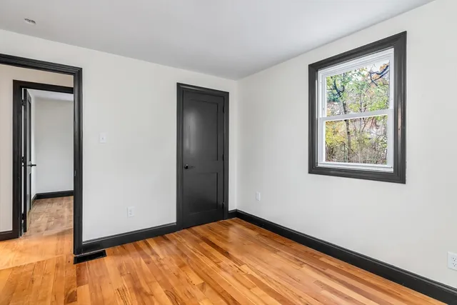 a view of an empty room with wooden floor