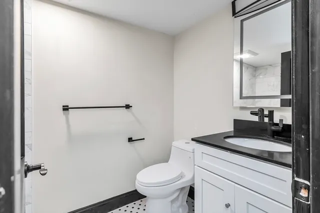 a bathroom with a granite countertop sink toilet and shower