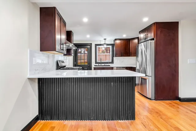 a kitchen with stainless steel appliances granite countertop a sink and a refrigerator
