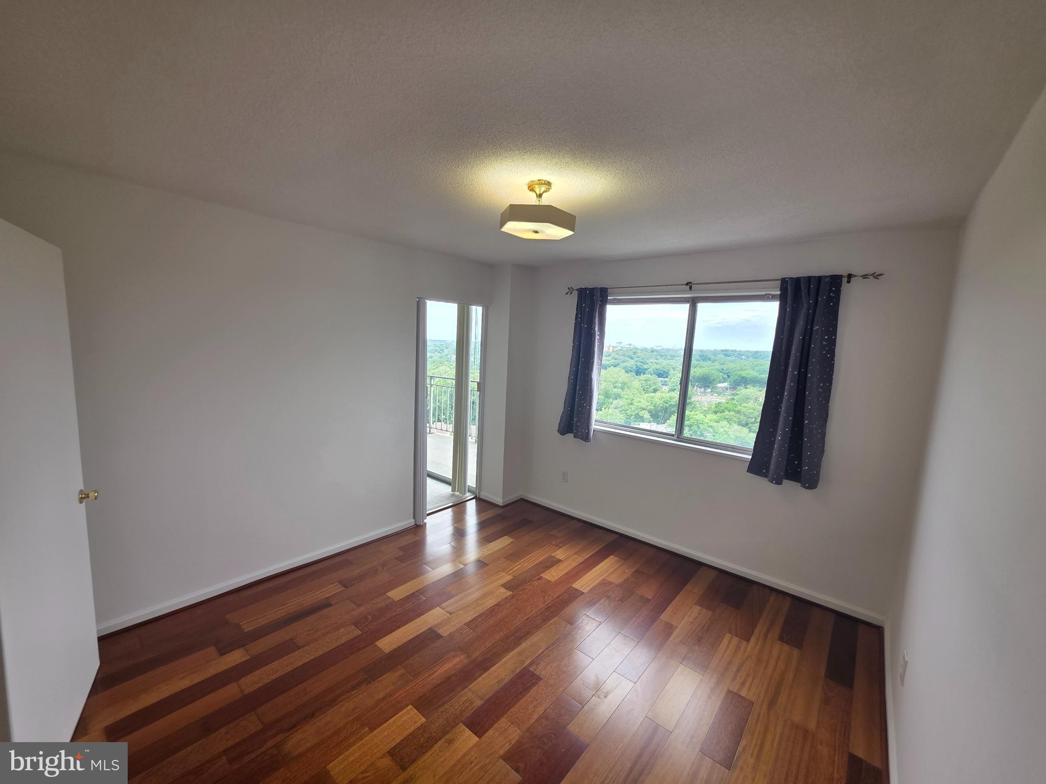 1836 Metzerott Road, Unit 1704 Adelphi, MD 20783 - Photo 29 of 47 a view of an empty room with wooden floor and a window