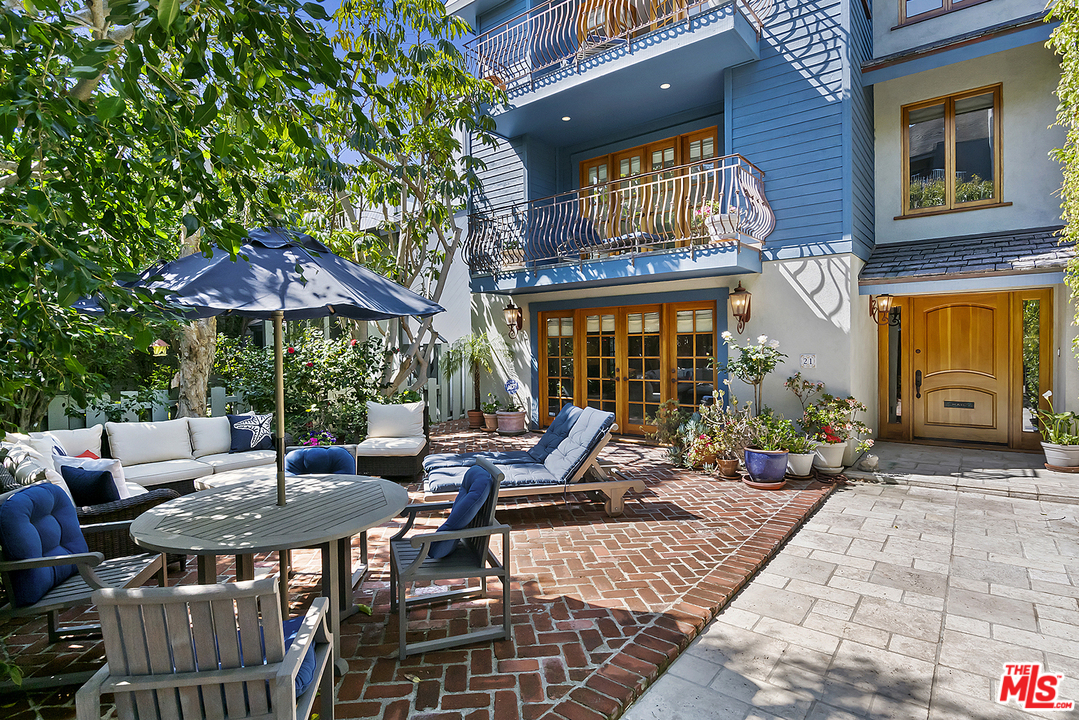 a view of a patio with a table and chairs under an umbrella
