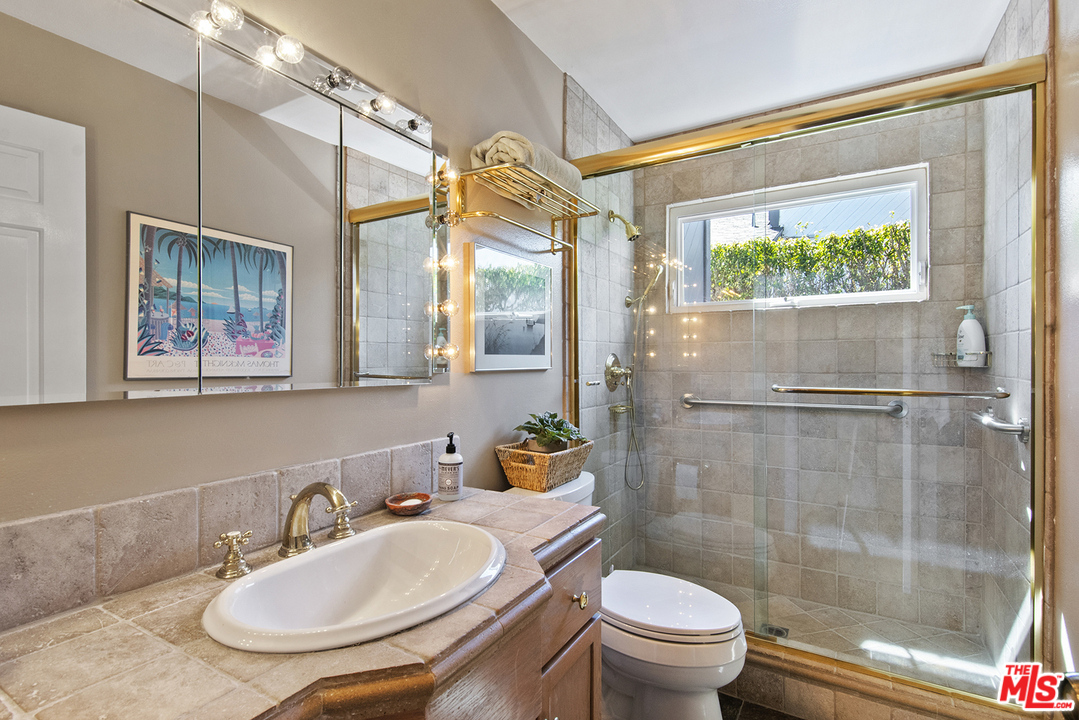 21 Westwind Street Marina del Rey, CA 90292 - Photo 47 of 52 a bathroom with a sink a toilet a mirror and a glass door shower