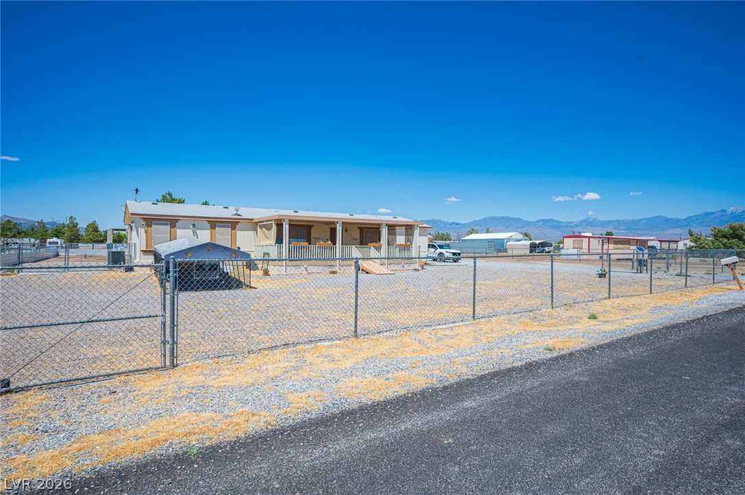 3200 Maple Road Pahrump, NV 89048 - Photo 3 of 53 Securely fenced and set against a mountain backdrop, this home offers a peaceful rural retreat.