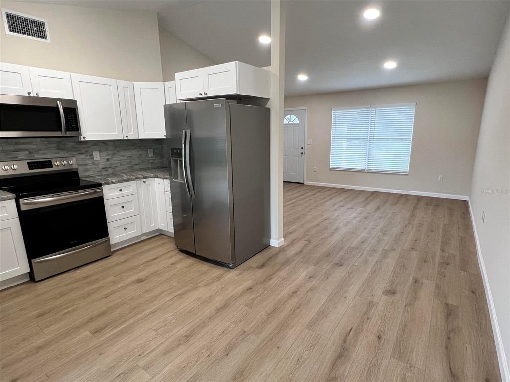 7224 Daggett Terrace New Port Richey, FL 34655 - Photo 3 of 14 a kitchen with stainless steel appliances granite countertop a refrigerator and a stove top oven