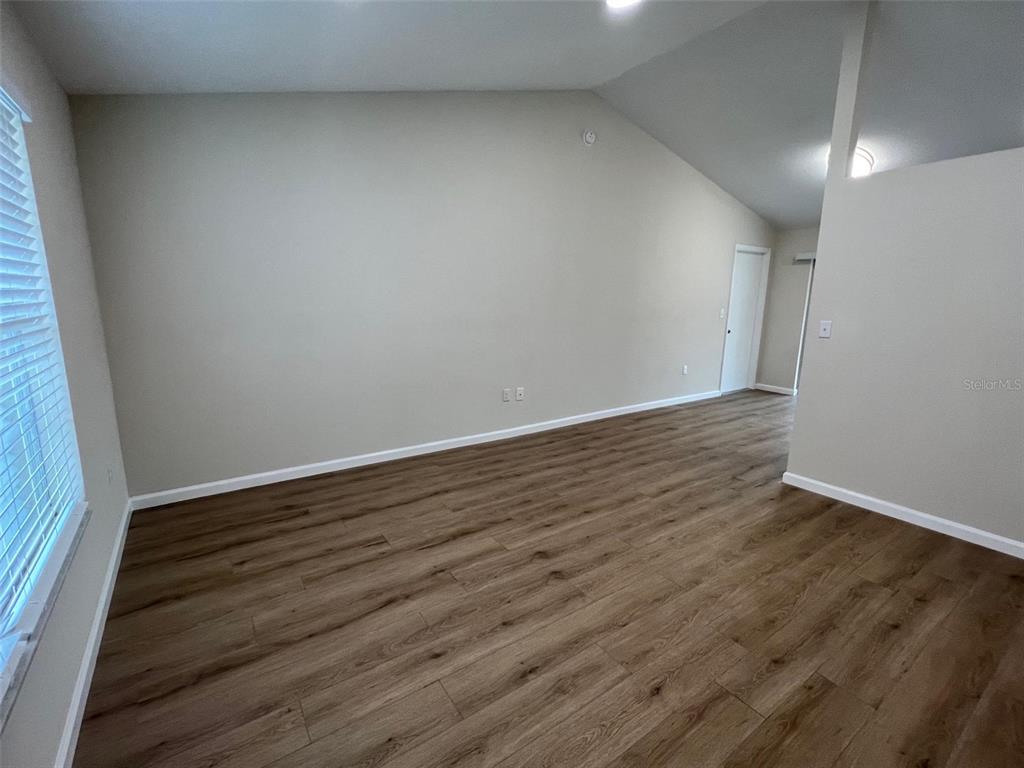 7224 Daggett Terrace New Port Richey, FL 34655 - Photo 5 of 14 a view of an empty room with wooden floor and a window