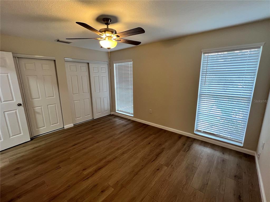 7224 Daggett Terrace New Port Richey, FL 34655 - Photo 8 of 14 an empty room with wooden floor fan and window