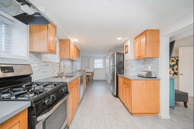 a kitchen with stainless steel appliances granite countertop a stove a sink and a refrigerator