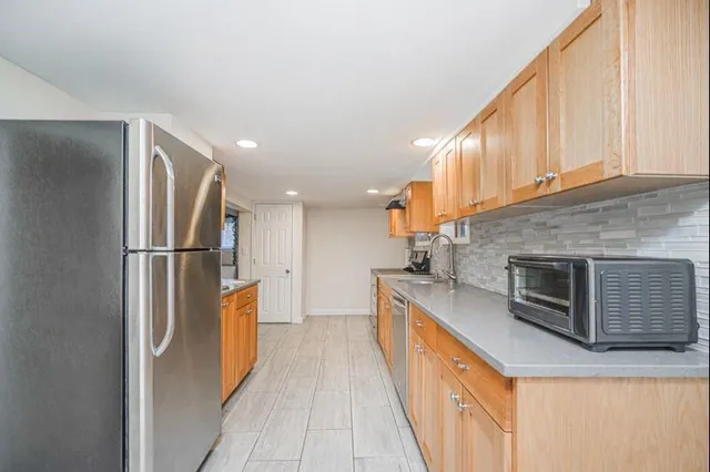 a kitchen with stainless steel appliances granite countertop a refrigerator a stove and a sink