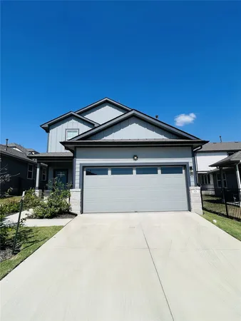a front view of a house with a yard and potted plants