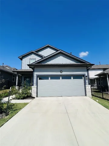 a front view of a house with a yard and potted plants