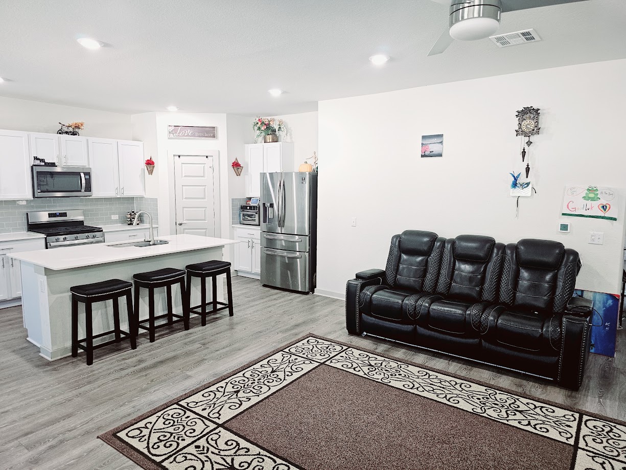 121 Merrick Road Georgetown, TX 78628 - Photo 8 of 29 a living room with furniture a flat screen tv and a refrigerator