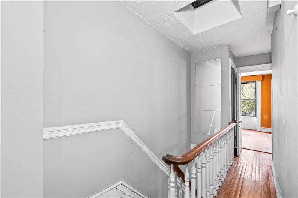 484 Decatur Street Brooklyn, NY 11233 - Photo 13 of 23 a view of a hallway with wooden floor and stairs
