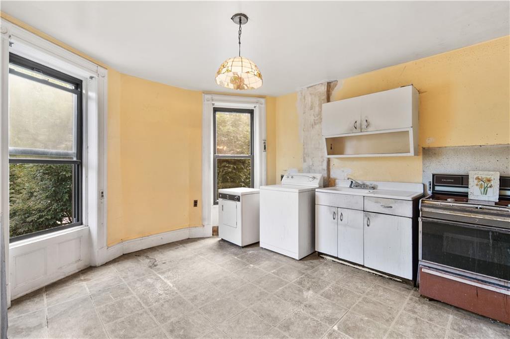 484 Decatur Street Brooklyn, NY 11233 - Photo 19 of 23 a kitchen that has a lot of white cabinets and wooden floor