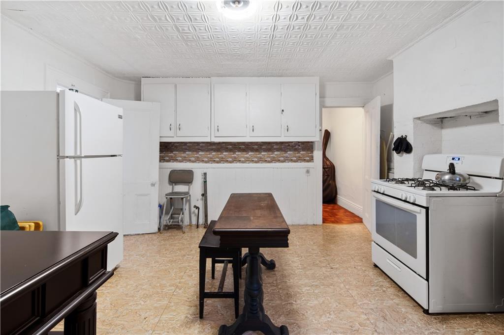 484 Decatur Street Brooklyn, NY 11233 - Photo 5 of 23 a kitchen with a stove and a refrigerator