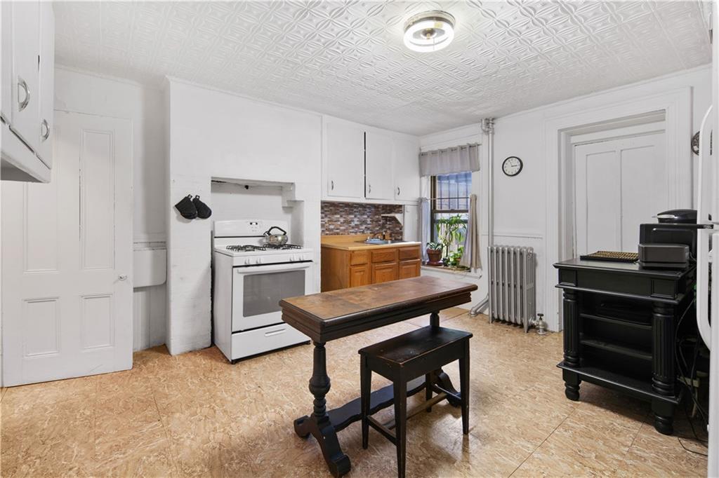 484 Decatur Street Brooklyn, NY 11233 - Photo 6 of 23 a kitchen with a refrigerator and a stove top oven