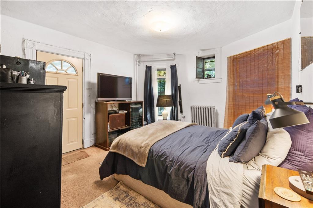 484 Decatur Street Brooklyn, NY 11233 - Photo 7 of 23 a bedroom with a bed and a television
