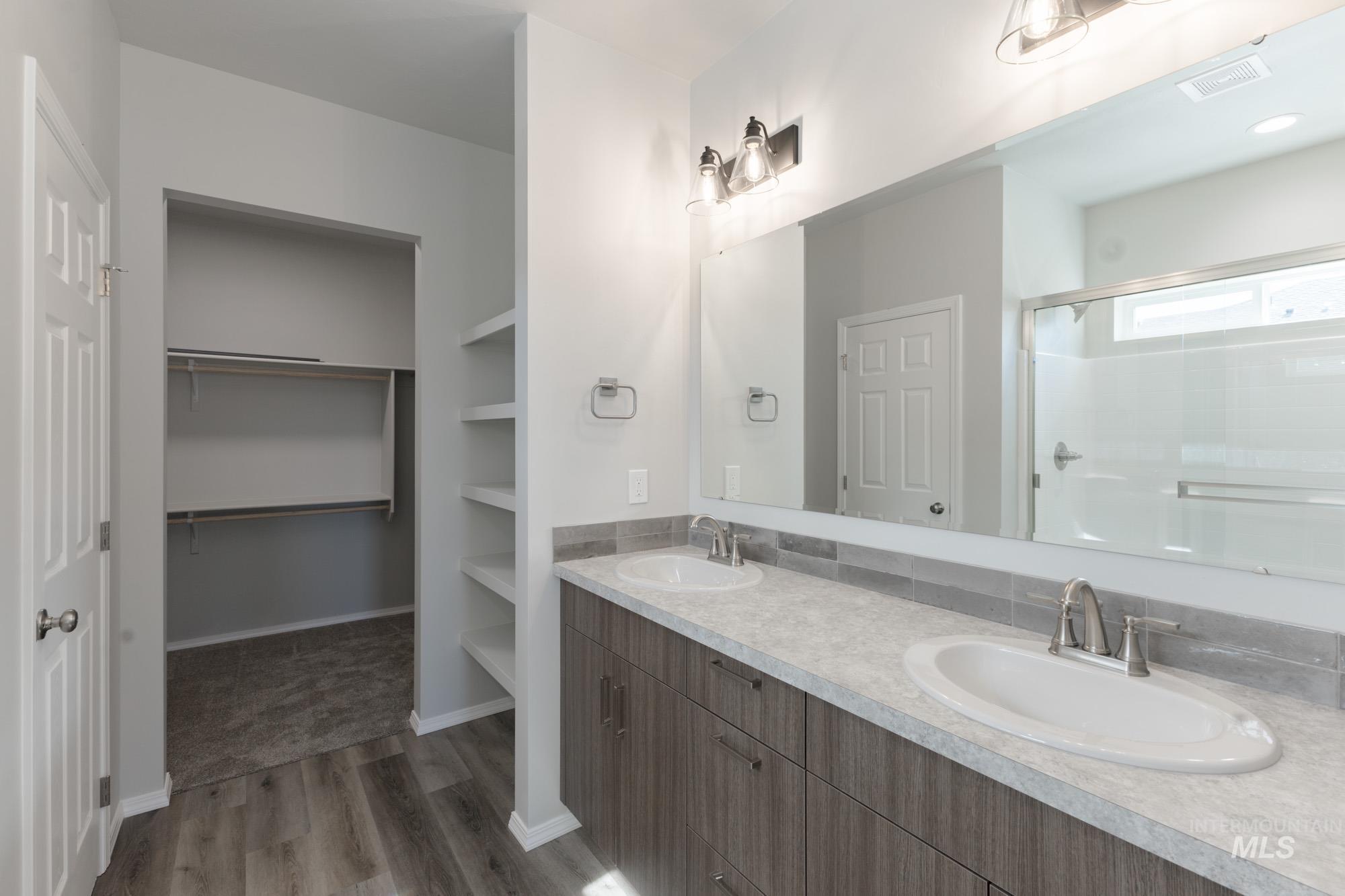 1459 Long Pond Street Middleton, ID 83644 - Photo 18 of 20 Full bath with double vanity, a shower stall, a spacious closet, and light wood finished floors