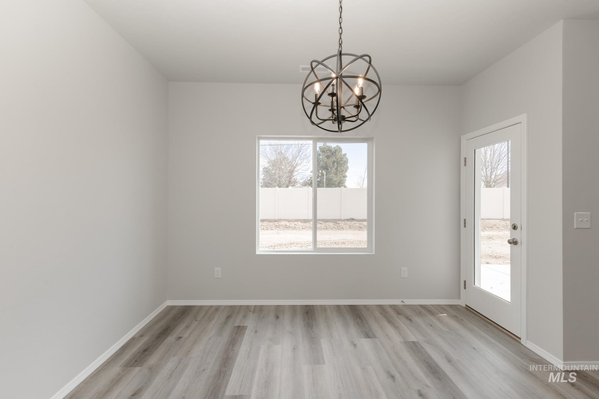 1459 Long Pond Street Middleton, ID 83644 - Photo 6 of 20 Unfurnished dining area featuring a chandelier and light wood-type flooring