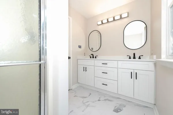 a bathroom with a double vanity sink and a mirror