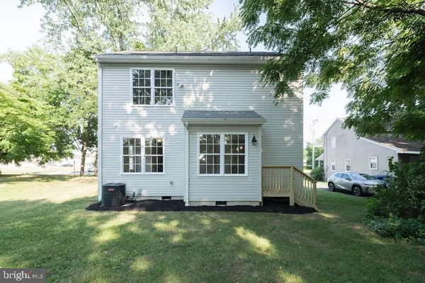 a view of a house with a yard and large tree