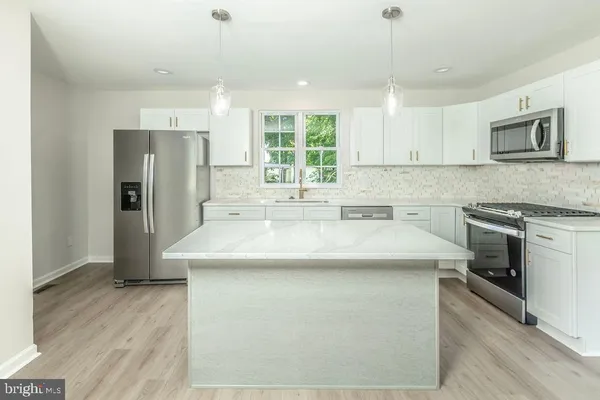 a kitchen with kitchen island a sink stove and refrigerator