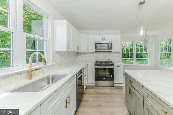 a kitchen with a sink stove top oven and cabinets