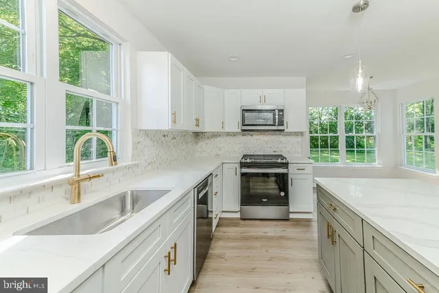 a kitchen with a sink stove top oven and cabinets