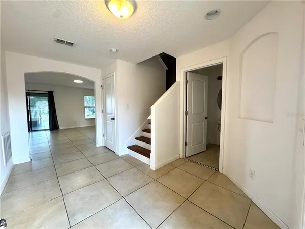 a view of a hallway with entryway and stairs