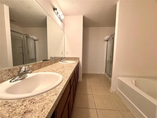 a bathroom with a tub sink and mirror