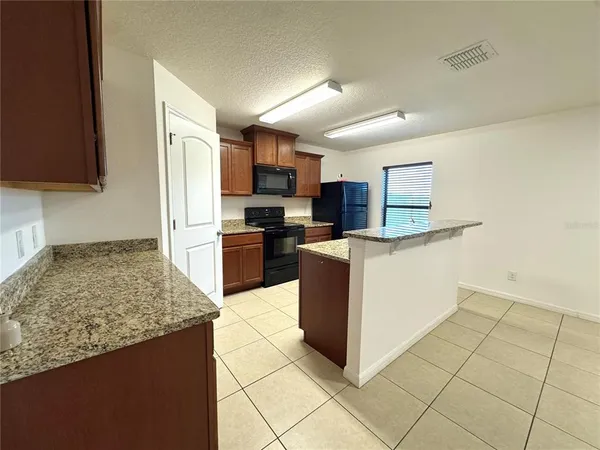 a kitchen with stainless steel appliances granite countertop a stove top oven a sink a counter top space and cabinets
