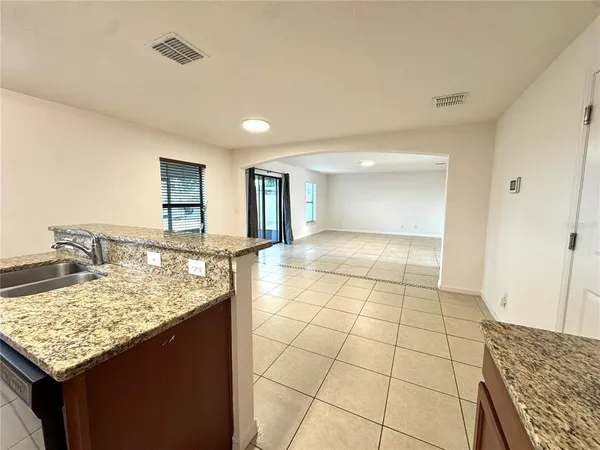 a kitchen with kitchen island granite countertop a sink cabinets and window