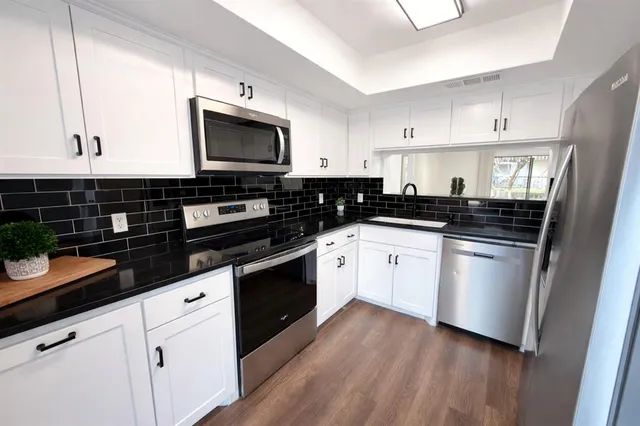 a kitchen with granite countertop a sink and a stove top oven