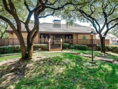 a view of a house with backyard and a tree