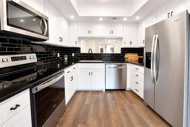 a kitchen with stainless steel appliances a stove sink and cabinets