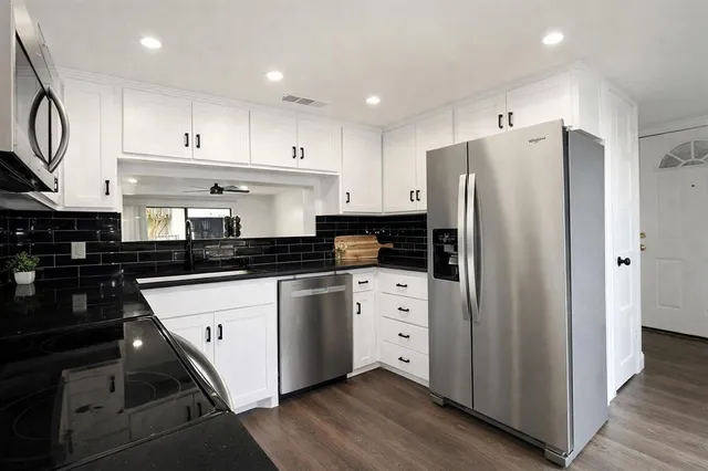 a kitchen with stainless steel appliances a refrigerator sink and cabinets