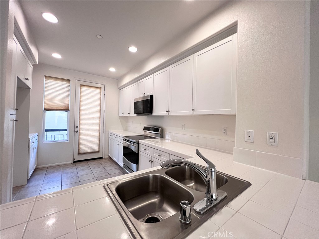58 South 5th Street, Unit F Alhambra, CA 91801 - Photo 8 of 24 a kitchen that has a sink and a stove with white countertops