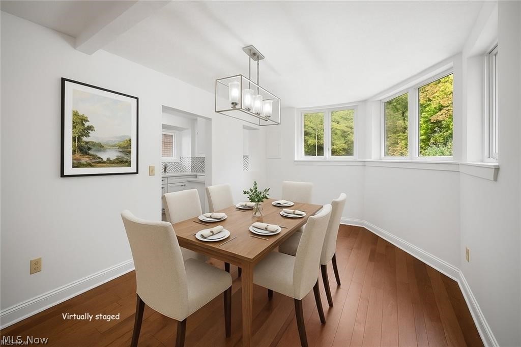 28300 Aurora Road Solon, OH 44139 - Photo 13 of 36 Dining area featuring wood-finish flooring, white trim, and a contemporary chandelier
