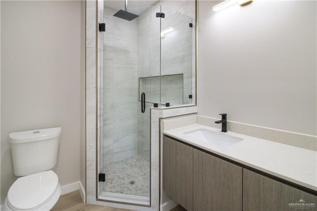 3429 May Street Mission, TX 78573 - Photo 12 of 16 a bathroom with a granite countertop sink toilet and shower