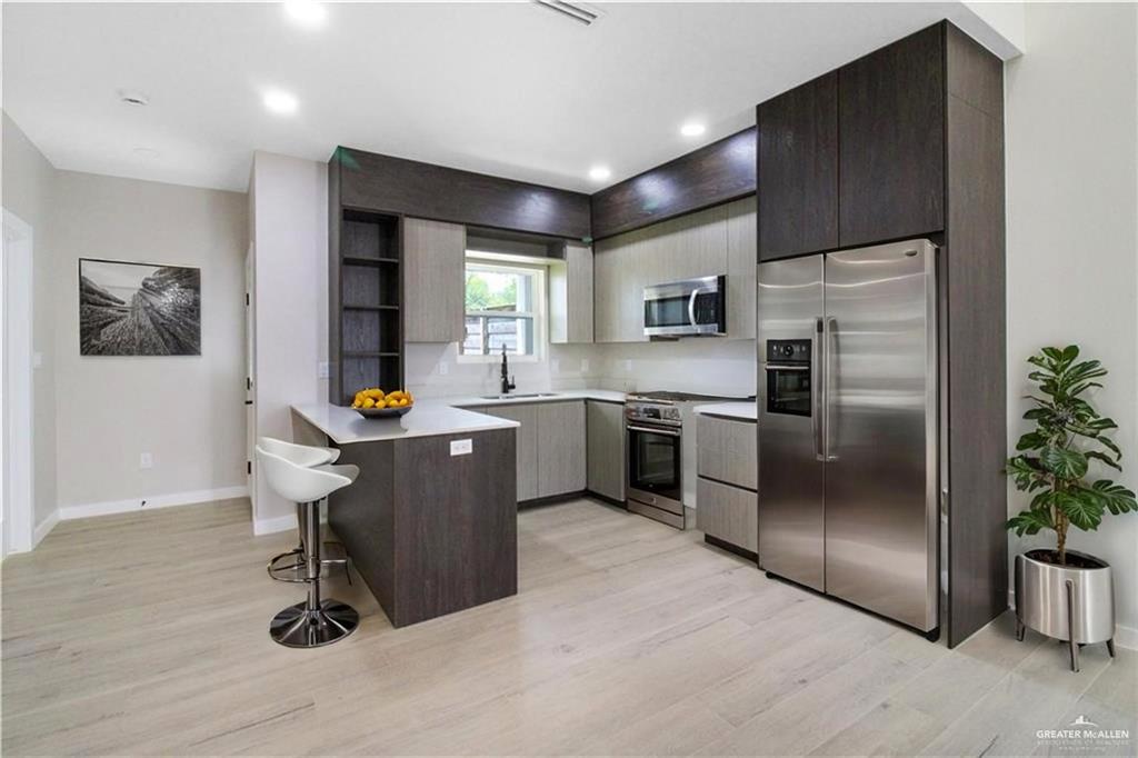 3429 May Street Mission, TX 78573 - Photo 2 of 16 a kitchen with stainless steel appliances granite countertop a refrigerator a sink a stove a microwave and wooden floors