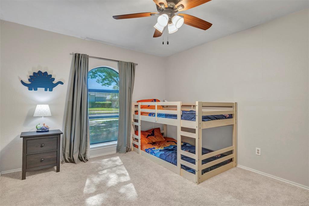 2317 Daybreak Trail Plano, TX 75093 - Photo 21 of 29 a bedroom with a bed and a chandelier
