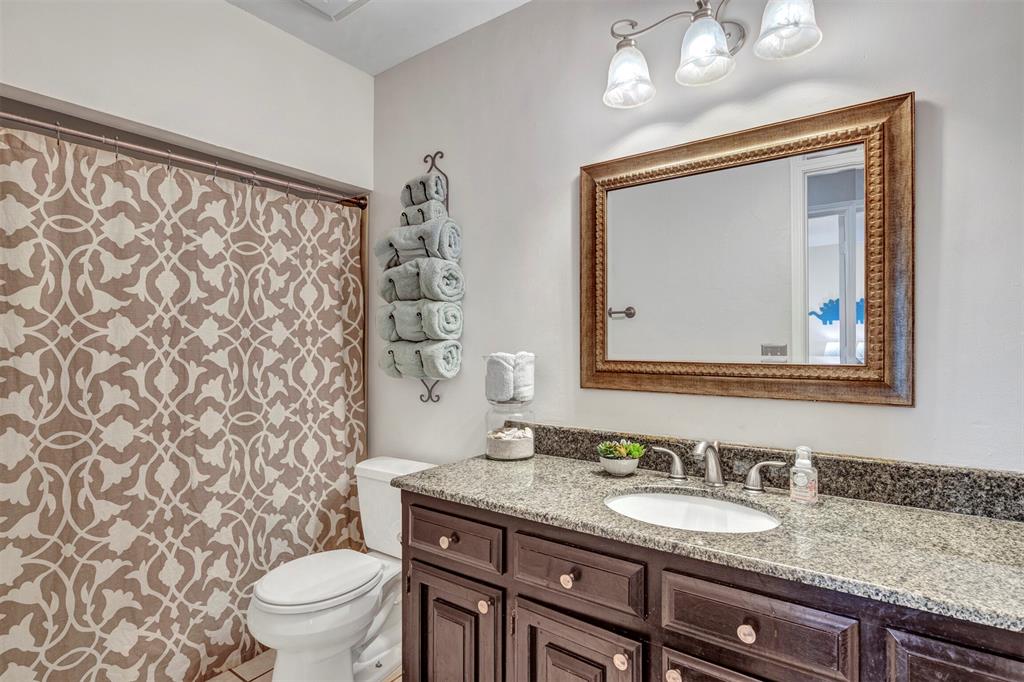 2317 Daybreak Trail Plano, TX 75093 - Photo 22 of 29 a bathroom with a granite countertop sink a toilet and a mirror